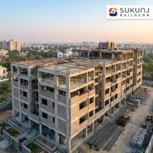 Modern residential building site in India displaying reinforced concrete columns, TMT steel rebar beams, and AAC block masonry walls under a clear sky.